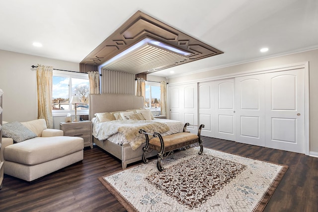 bedroom with crown molding, dark wood-type flooring, and a closet