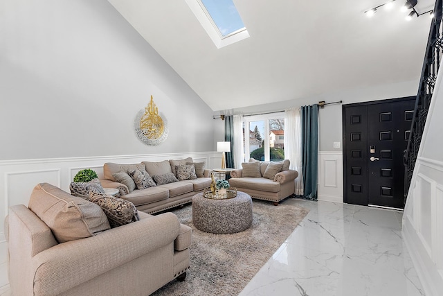 living room with a skylight and high vaulted ceiling