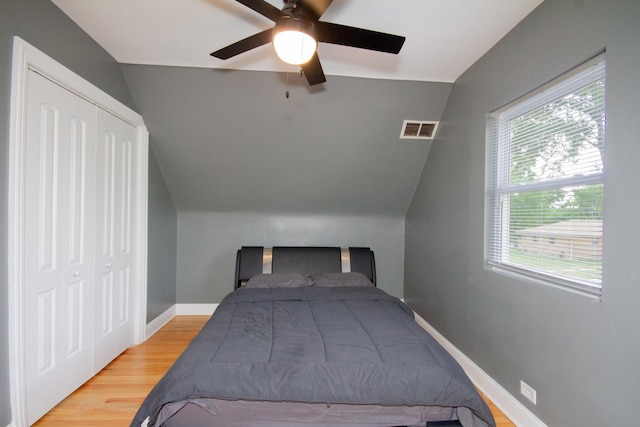 bedroom with lofted ceiling, ceiling fan, a closet, and light hardwood / wood-style floors