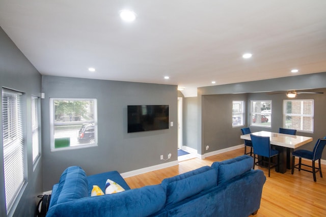 living room featuring ceiling fan and light hardwood / wood-style floors