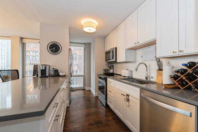 kitchen with white cabinetry, appliances with stainless steel finishes, sink, and backsplash