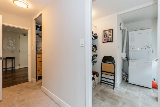 corridor featuring light colored carpet and stacked washer and clothes dryer