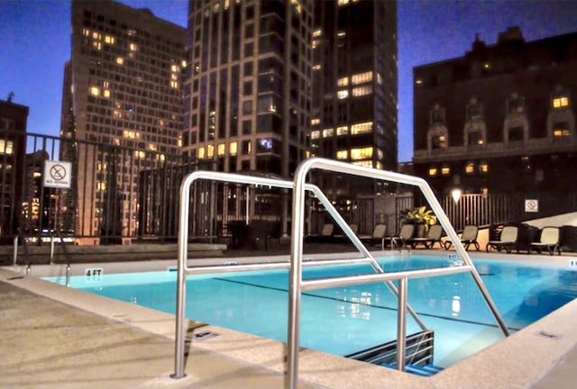 view of pool at twilight