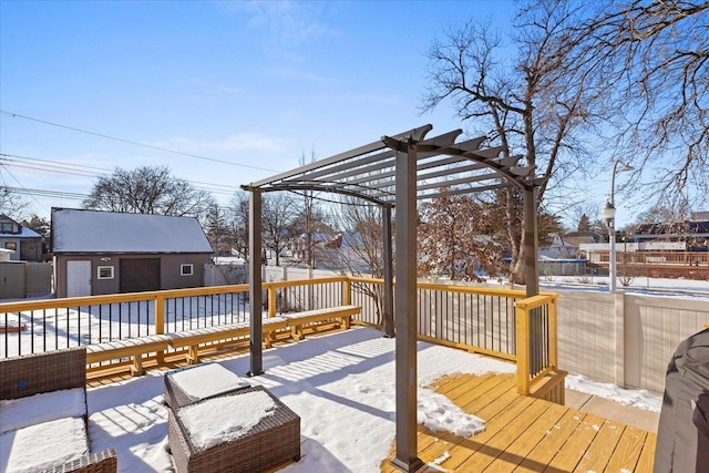 snow covered deck featuring a pergola and a storage unit