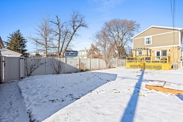 yard covered in snow featuring a wooden deck and central AC unit