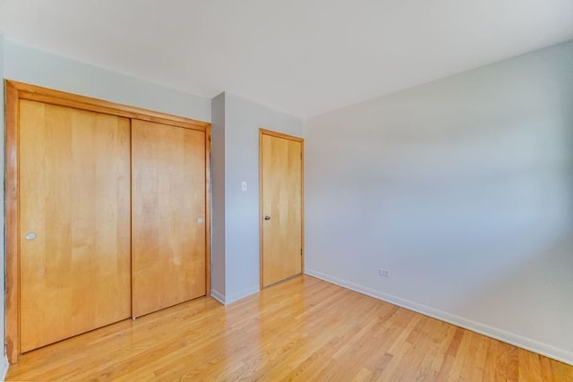 unfurnished bedroom featuring light wood-type flooring and a closet