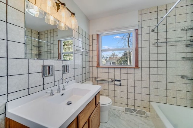 bathroom with toilet, vanity, and tile walls