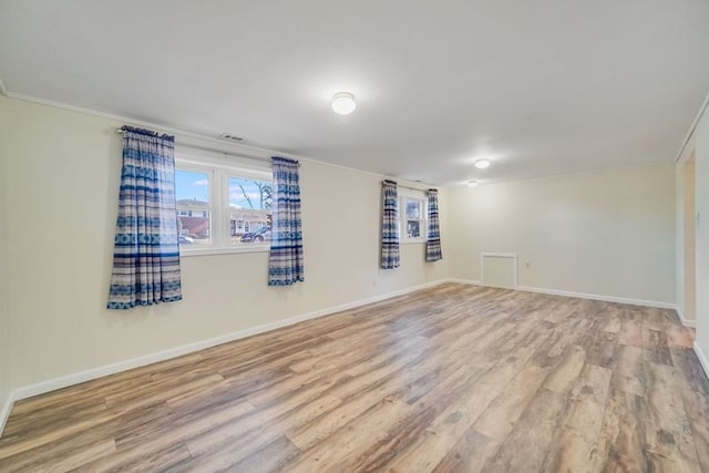 spare room featuring light hardwood / wood-style floors and ornamental molding