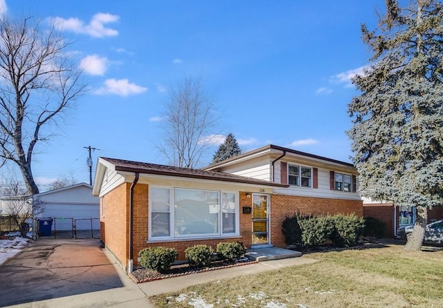 tri-level home with a garage, an outbuilding, and a front yard