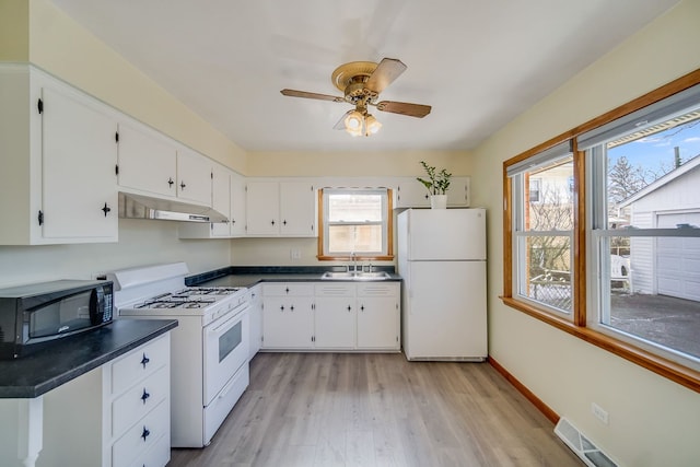 kitchen featuring white appliances, light hardwood / wood-style floors, white cabinetry, sink, and ceiling fan