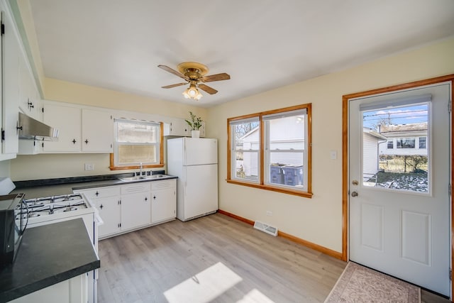 kitchen with ceiling fan, sink, white cabinets, white appliances, and light hardwood / wood-style floors