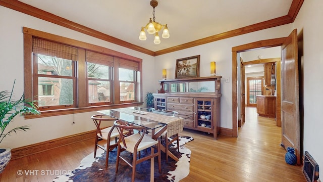 dining space featuring an inviting chandelier, light hardwood / wood-style flooring, and ornamental molding