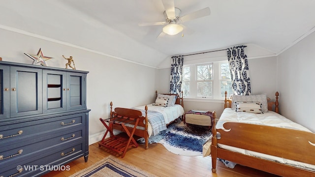 bedroom featuring lofted ceiling, crown molding, light hardwood / wood-style floors, and ceiling fan