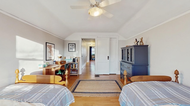 bedroom with hardwood / wood-style flooring, ornamental molding, lofted ceiling, and ceiling fan