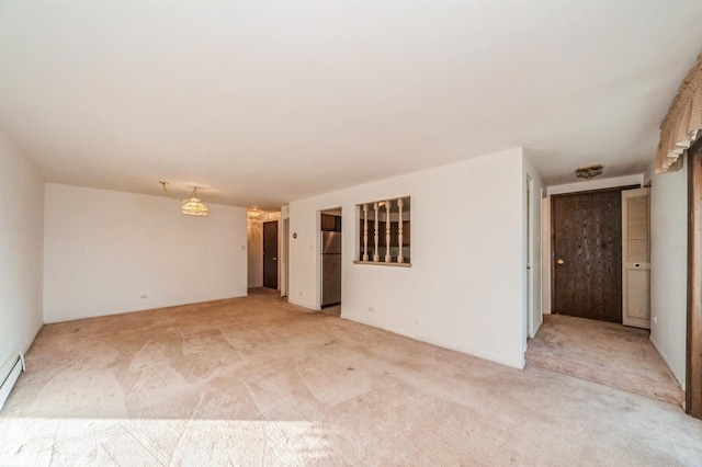 carpeted spare room featuring a baseboard radiator