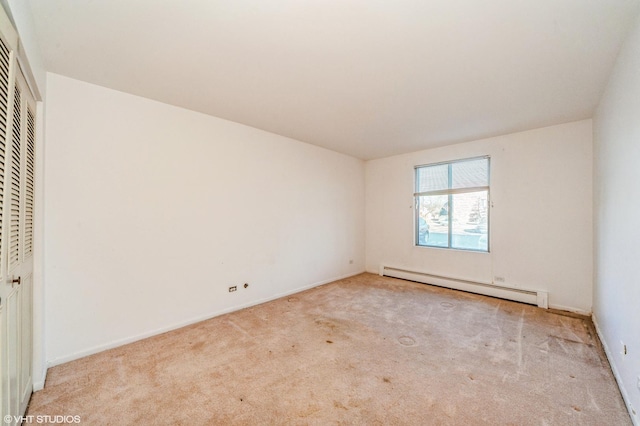 carpeted spare room with a baseboard radiator