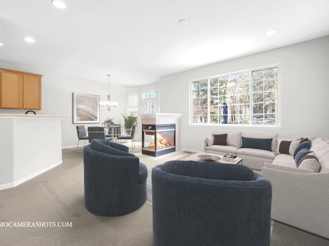 carpeted living room featuring a multi sided fireplace and a notable chandelier