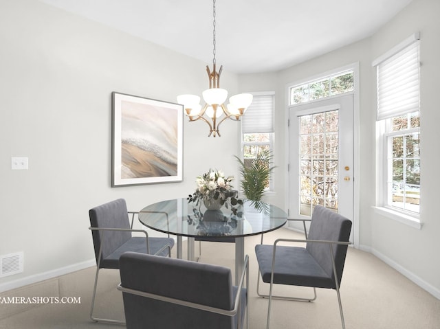 dining space featuring carpet floors and an inviting chandelier