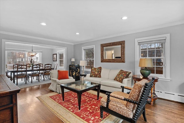 living room with an inviting chandelier, crown molding, and hardwood / wood-style floors