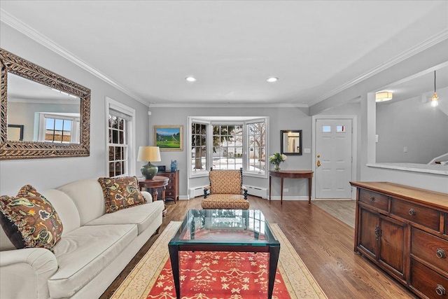 living room with baseboard heating, light hardwood / wood-style flooring, and crown molding