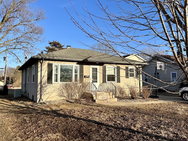 view of front of home featuring roof with shingles and stucco siding