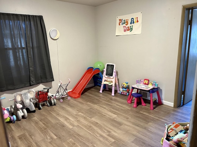 recreation room featuring wood finished floors and baseboards