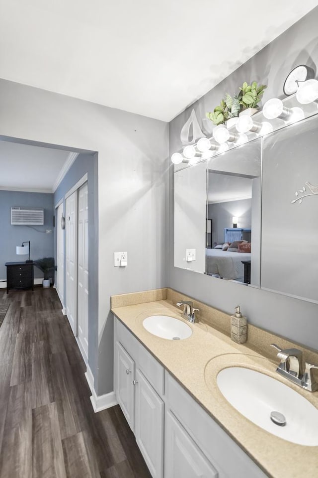 bathroom with ornamental molding, vanity, a wall mounted AC, and hardwood / wood-style floors