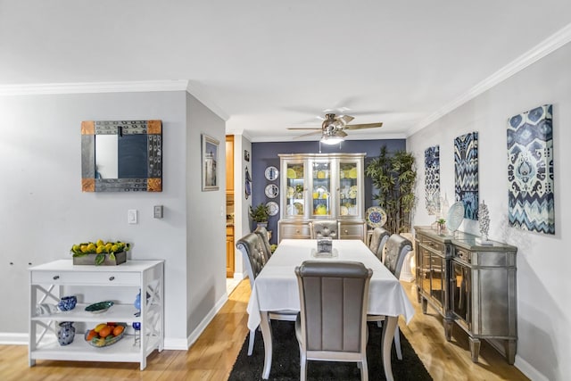 dining area with ceiling fan, ornamental molding, and light hardwood / wood-style floors