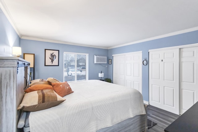 bedroom with dark wood-type flooring, ornamental molding, and two closets