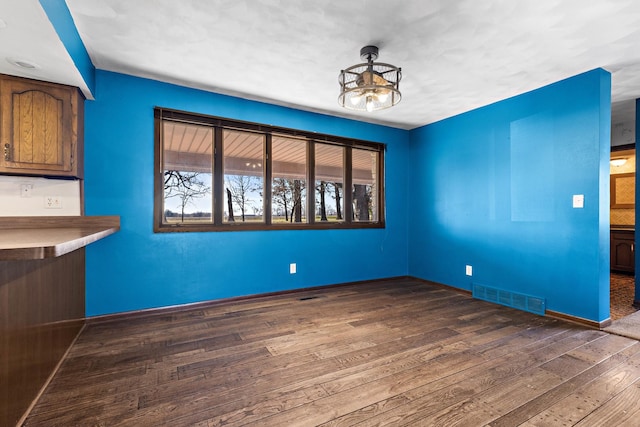 unfurnished dining area featuring dark hardwood / wood-style floors