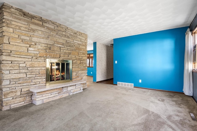 unfurnished living room with carpet floors and an outdoor stone fireplace