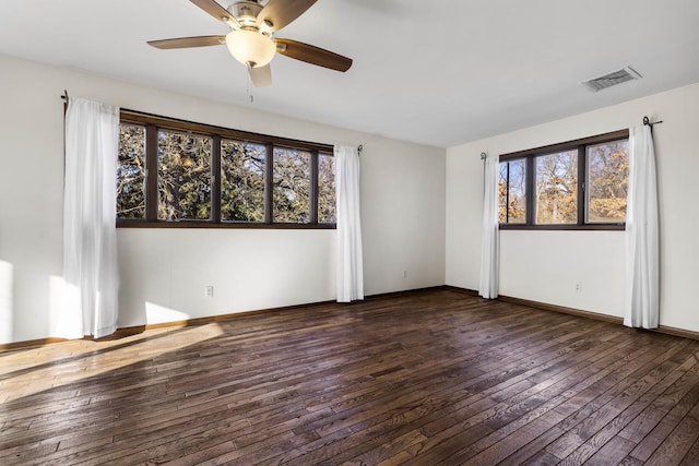 unfurnished room featuring ceiling fan, dark hardwood / wood-style floors, and a healthy amount of sunlight