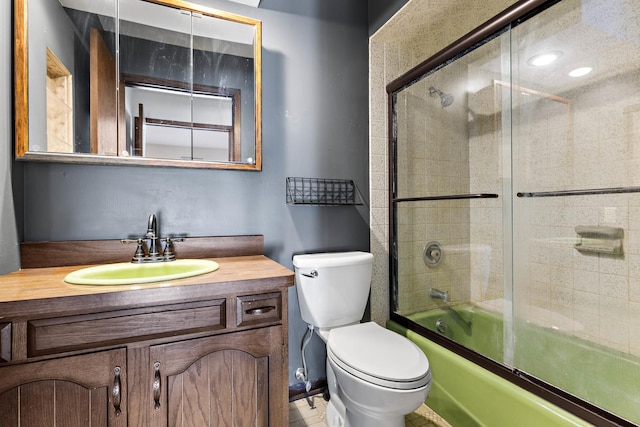 full bathroom with toilet, combined bath / shower with glass door, and vanity