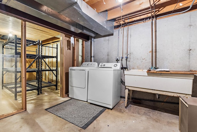 basement featuring independent washer and dryer and sink