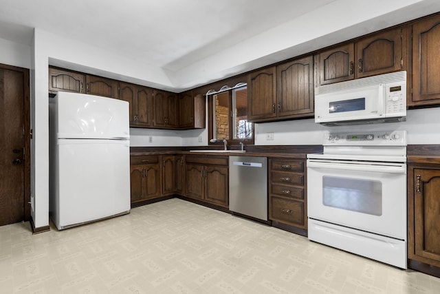 kitchen featuring sink, white appliances, and dark brown cabinetry