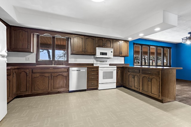 kitchen with sink, white appliances, and dark brown cabinetry