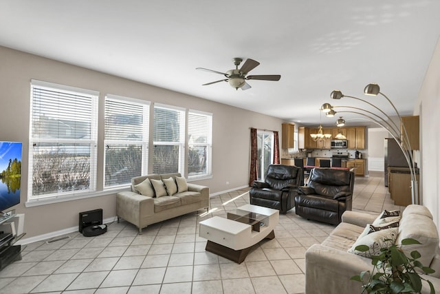 tiled living room featuring ceiling fan with notable chandelier