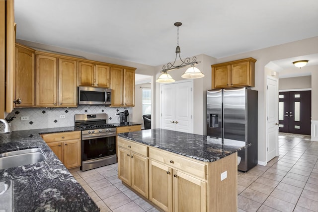 kitchen with a center island, stainless steel appliances, decorative backsplash, hanging light fixtures, and light tile patterned floors