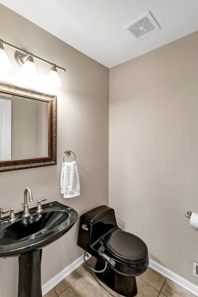 bathroom with sink, toilet, and tile patterned flooring