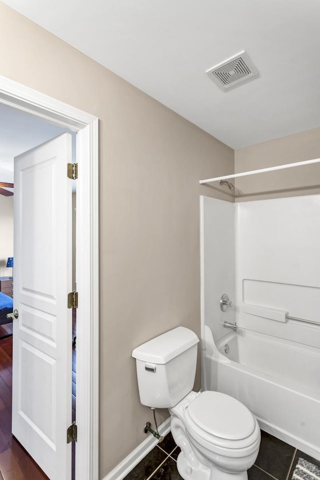 bathroom with toilet, shower / bathtub combination, and tile patterned flooring