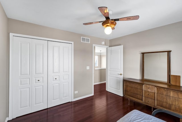 unfurnished bedroom with ceiling fan, a closet, and dark hardwood / wood-style flooring