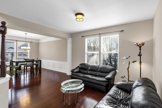 living room featuring dark hardwood / wood-style flooring and ornate columns