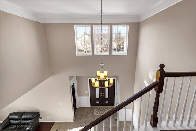 stairs with ornamental molding and a chandelier