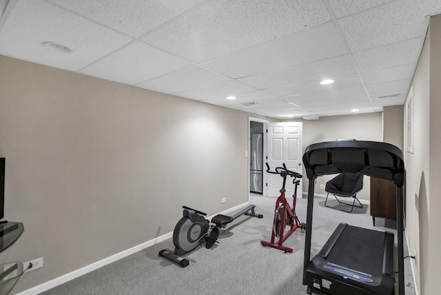 exercise room featuring carpet and a paneled ceiling