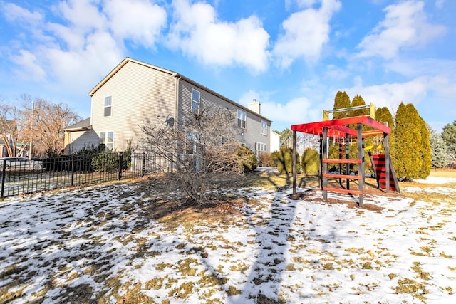 snow covered house featuring a playground