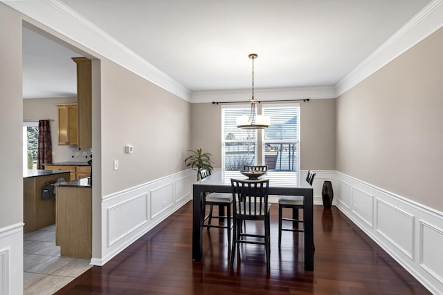 dining space featuring ornamental molding, plenty of natural light, and dark hardwood / wood-style flooring