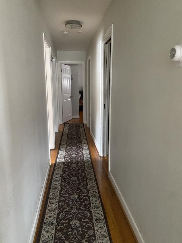 corridor with hardwood / wood-style floors