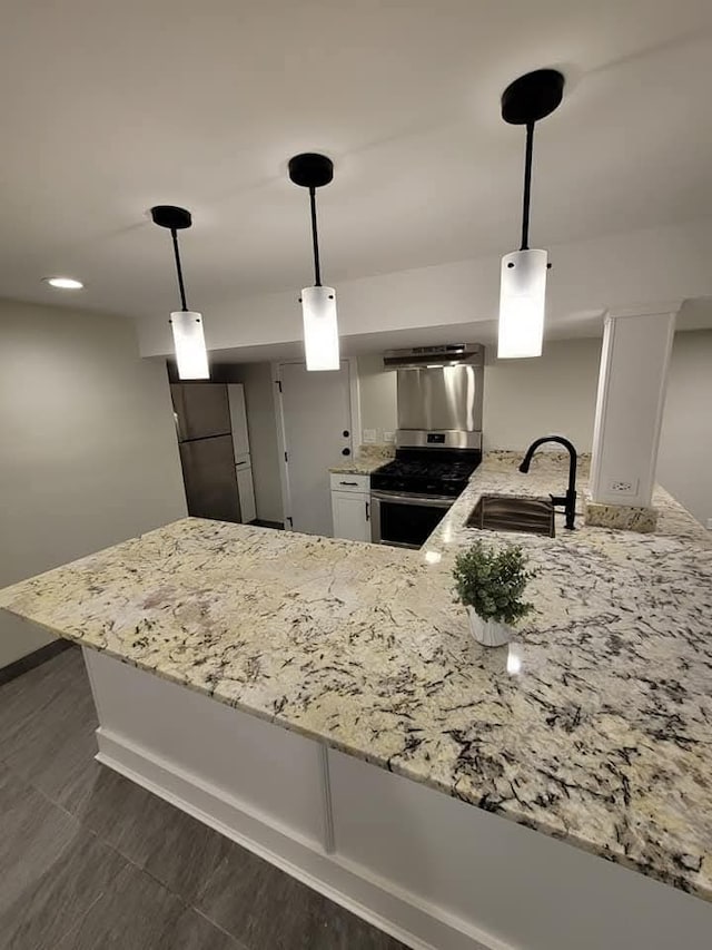 kitchen featuring appliances with stainless steel finishes, sink, white cabinets, hanging light fixtures, and kitchen peninsula