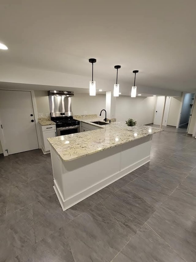 kitchen featuring decorative light fixtures, sink, white cabinets, kitchen peninsula, and stainless steel range with gas stovetop