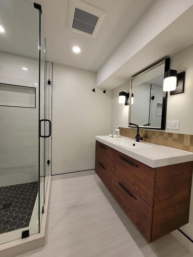 bathroom with vanity and a shower with shower door